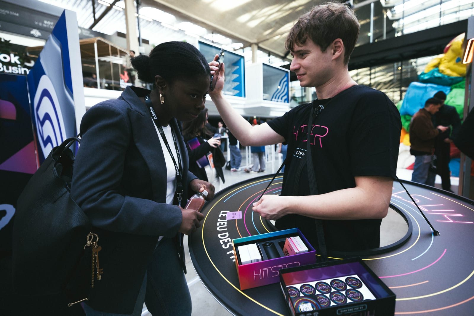 Des participants testent le jeu Hitster sur le stand