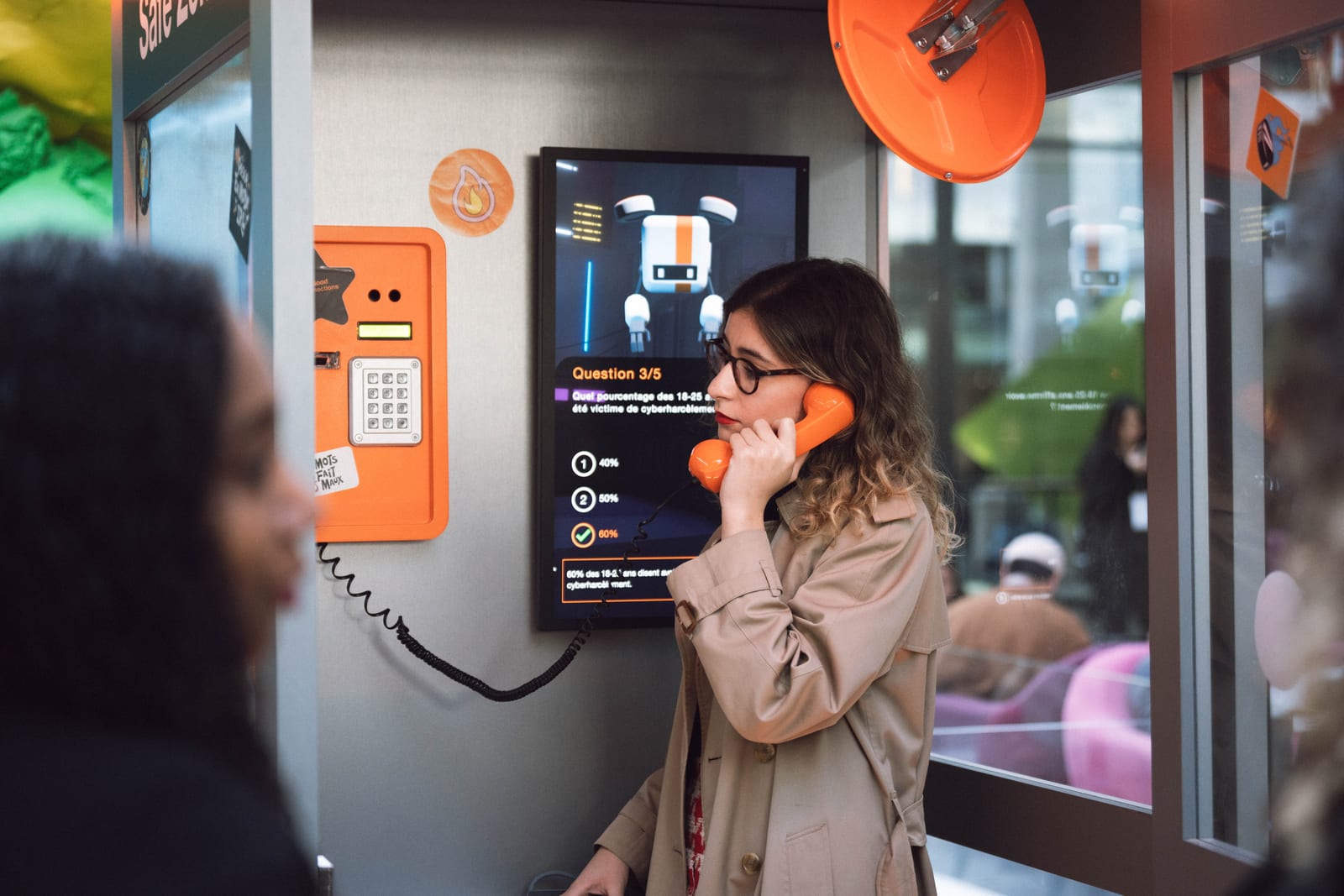 Cabine téléphonique orange interactive - un participant en plein jeu
