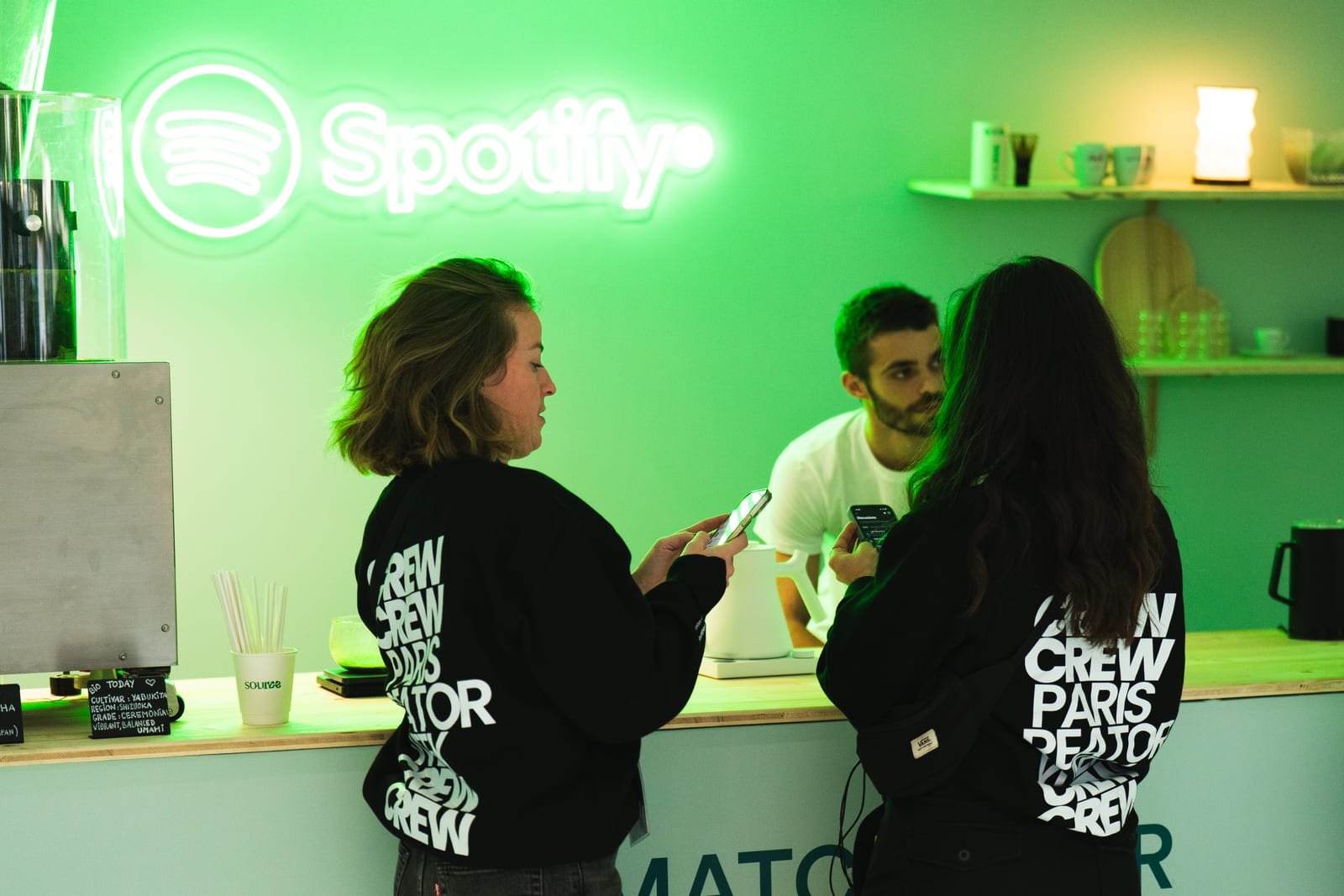 Participants au stand Spotify, baigné de néons